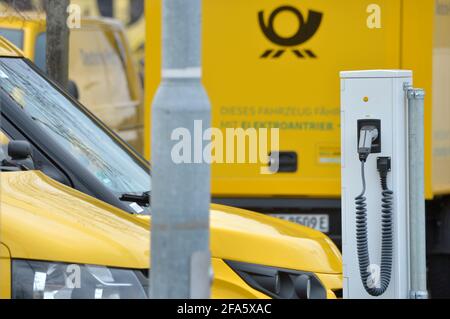 01. April 2021, Sachsen, Leipzig: 'Dieses Fahrzeug läuft mit Strom'. Mehrere der StreetScooter-Elektrotransporter der Deutschen Post stehen an Ladestationen an einem DHL-Standort in Leipzig. Foto: Volkmar Heinz/dpa-Zentralbild/ZB Stockfoto