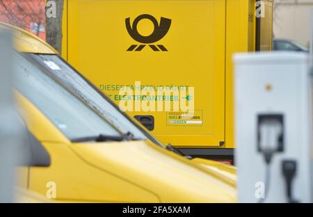 01. April 2021, Sachsen, Leipzig: 'Dieses Fahrzeug läuft mit Strom'. Mehrere der StreetScooter-Elektrotransporter der Deutschen Post stehen an Ladestationen an einem DHL-Standort in Leipzig. Foto: Volkmar Heinz/dpa-Zentralbild/ZB Stockfoto