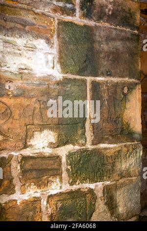 KINLOSS ABBEY MORAY SCHOTTLAND DER BLICK AUF DAS INNERE MIT GRAFFITI AN DER WAND IN DER NÄHE DES FENSTERS Stockfoto