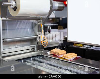 Paket von Wurst auf Lebensmittel Vakuumverpackung Versiegelungsmaschine in Lebensmittelfabrik Stockfoto