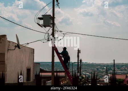 Johannesburg Südafrika 22. April 2021 EIN eskom-Mitarbeiter arbeitet an einem Strommast im Ebenholz-Park. Stockfoto