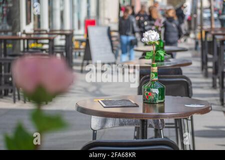 Vilnius hat Bars und Restaurants nach der Sperrung aufgrund von Covid oder Coronavirus wieder geöffnet, Tische, Stühle und Sonnenschirme stehen bereit, um zu öffnen, aufzustehen und die Speisekarte zu öffnen Stockfoto