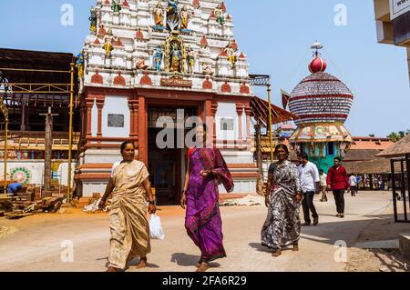 Udupi, Karnataka, Indien : Frauen gehen am Gopuram-Turm des Krishna-Tempels aus dem 13. Jahrhundert vorbei. Der Tempel wurde von der lokalen Hindu-heiligen Madhva gegründet Stockfoto