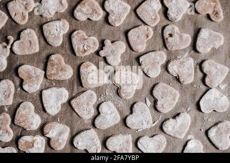 Hausgemachtes Weihnachtsbacken, herzförmige Lebkuchenkekse auf einem Holzbrett Stockfoto