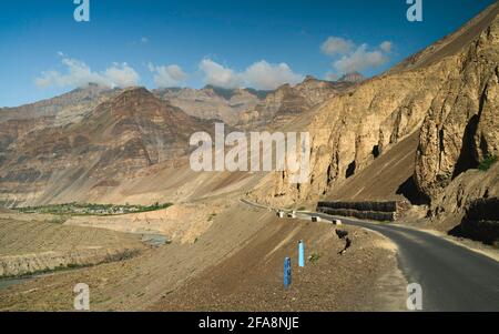 Blick auf die großen Highways und Himalaya-Gipfel mit tiefem Tal, Fluss und kleinem Dorf unter blauem Himmel in der Nähe von Tabo, Himachal Pradesh, Indien. Stockfoto