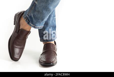 Nahaufnahme eines Männerbeins in Jeans mit Lederschuhen Isoliert auf weißem Hintergrund Stockfoto