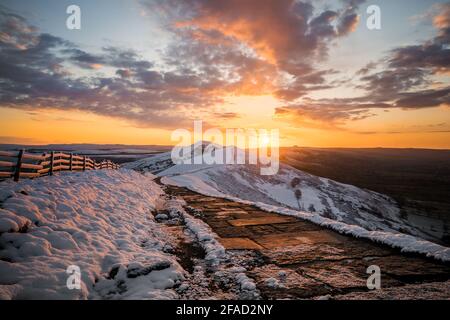 Atemberaubende Winter schneebedeckten Berge Hügel Gipfel Sonnenaufgang. MAM Tor Derbyshire Peak District Bergrücken Wandern im Winter Snow Valley goldene Sonne Stockfoto