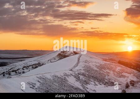 Atemberaubende Winter schneebedeckten Berge Hügel Gipfel Sonnenaufgang. MAM Tor Derbyshire Peak District Bergrücken Wandern im Winter Snow Valley goldene Sonne Stockfoto