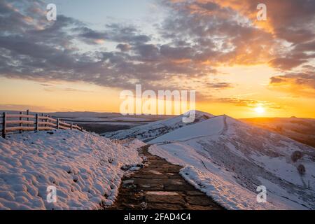 Atemberaubende Winter schneebedeckten Berge Hügel Gipfel Sonnenaufgang. MAM Tor Derbyshire Peak District Bergrücken Wandern im Winter Snow Valley goldene Sonne Stockfoto