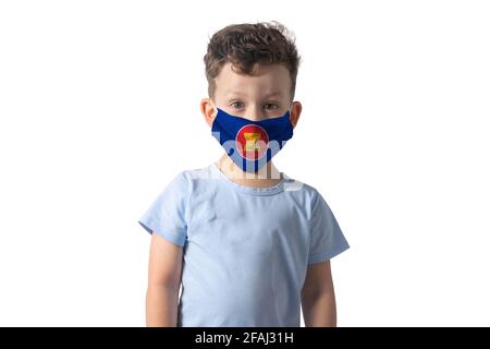 Atemschutzmaske mit Flagge der Association of Southeast Asian Nations. Weißer Junge setzt auf medizinische Gesichtsmaske isoliert auf weißem Hintergrund. Stockfoto