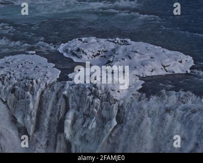 Schöner Blick auf die untere Kaskade des Gullfoss-Wasserfalls im Südwesten Islands, Teil des berühmten Goldenen Kreises, in der Wintersaison mit Schnee und Eiszapfen. Stockfoto