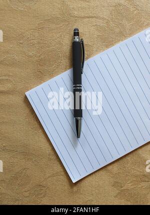 Ein dunkelgrauer Stift auf einem leeren Notizpad Stockfoto
