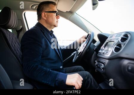 Schöner Mann mittleren Alters, der ein Auto fährt Stockfoto