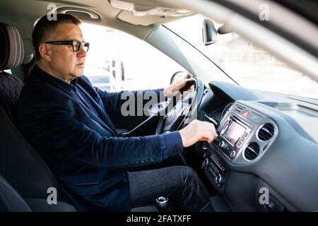 Transport- und Fahrzeugkonzept, Matureman mit Auto-Audio-Stereo-System Stockfoto