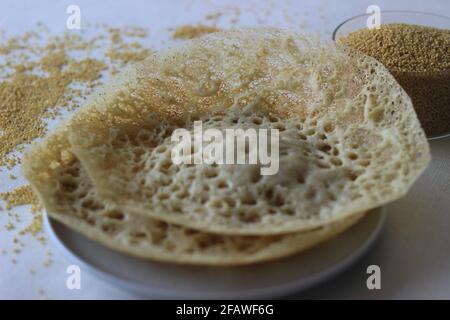 Trichter aus Füchsschwanzmilchetten. Eine experimentelle Version eines beliebten Kerala-Tellers namens Appam. Aufgenommen auf weißem Hintergrund. Stockfoto