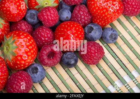 Vielfalt der Beeren - Trawbeeren, Heidelbeeren, Himbeeren verstreut Stockfoto