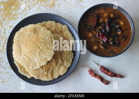 Reispfannkuchen aus Milchmehl mit Fuchsschwanz. Eine experimentelle Version eines beliebten Kerala-Tellers namens Kallapam serviert mit Chana Masala, einem Gericht hergestellt Stockfoto