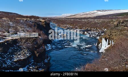 Schöne Aussicht auf die Hraunfossar-Kaskaden (isländisch: Lavafälle) bei Húsafell im Westen Islands am sonnigen Wintertag mit wildem Fluss. Stockfoto