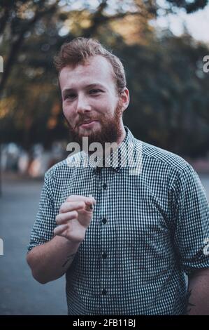 Smiley Hipster-Stil Mann rauchen Zigarette im Freien Stockfoto