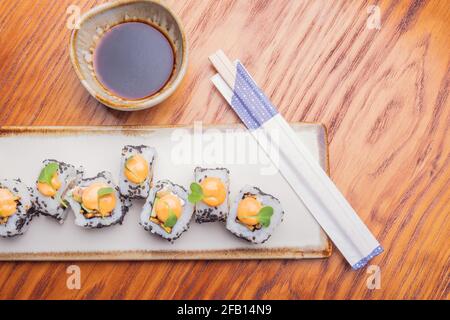 Draufsicht auf Sushi-Rollen mit Sesamsamen auf einem Weiße Platte Stockfoto