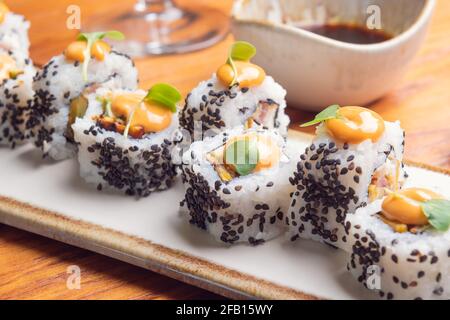 Nahaufnahme von Sushi-Rollen mit Sesamsamen Eine weiße Platte Stockfoto
