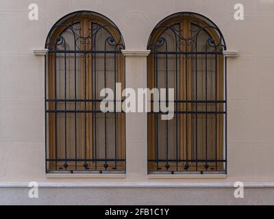 Zwei Vintage-Fenster mit Eisengitter an einer Steinwand. Valencia, Spanien Stockfoto