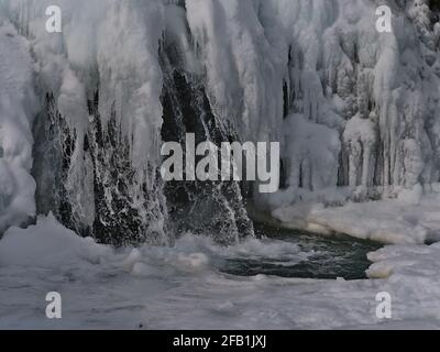 Nahaufnahme der gefrorenen Kaskade Kirkjufellsfoss bei Grundarfjörður auf der Halbinsel Snæfellsnes, Westisland in der Wintersaison mit Spritzwasser. Stockfoto