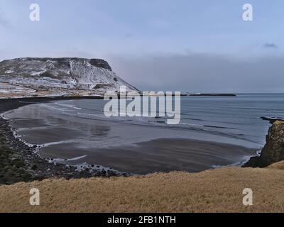 Schöne Aussicht auf das kleine Dorf Ólafsvík an der Nordküste der Halbinsel Snæfellsnes, Westisland in der Wintersaison mit schwarzem Sandstrand. Stockfoto