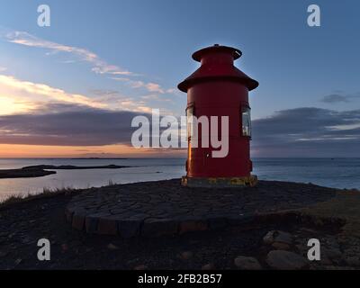 Wunderschöne Sonnenuntergangsansicht des roten Leuchtturms Súgandisey auf einer Insel in Stykkishólmur, Halbinsel Snæfellsnes, Westisland an der Küste. Stockfoto