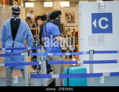 Richmond, Kanada. April 2021. Ein Passagier aus Indien wartet in der Ankunftshalle des Vancouver International Airport in Richmond, British Columbia, Kanada, am 23. April 2021 auf den COVID-19-Test. Kanada kündigte am Donnerstag ein 30-tägiges Verbot aller Flüge von Indien und Pakistan an, da die COVID-19-Fälle in den beiden Ländern weiter ansteigenden. Quelle: Liang Sen/Xinhua/Alamy Live News Stockfoto