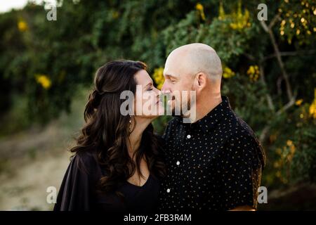 Ehemann und Ehefrau kuscheln im Garten in San Diego Stockfoto