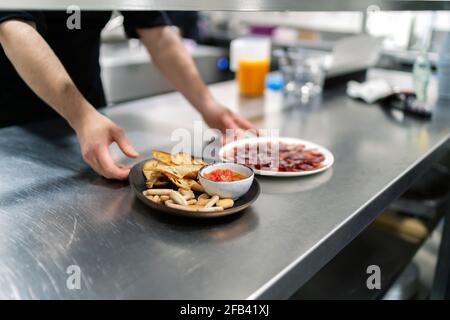 Cook serviert einen Teller frisch geschnittenen Schinken Stockfoto