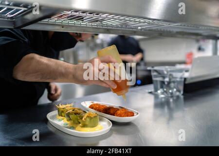 Der Küchenchef setzt Sauce auf seine köstlichen Rezepte Stockfoto