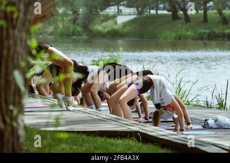 Gesunder Lebensstil. Sportler machen Übungen am Sommerufer des Flusses Stockfoto