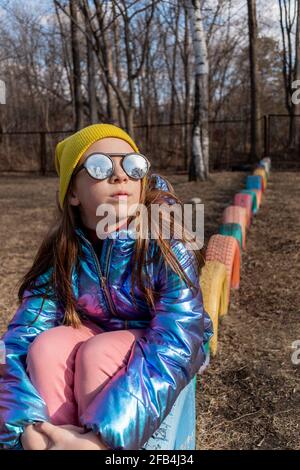 Teenager-Mädchen in verspiegelter Sonnenbrille blickt in den Himmel. Wellness-Konzept Stockfoto