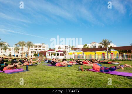 Eine Gruppe von Touristen, die im Hotel Yoga im Freien machen Stockfoto