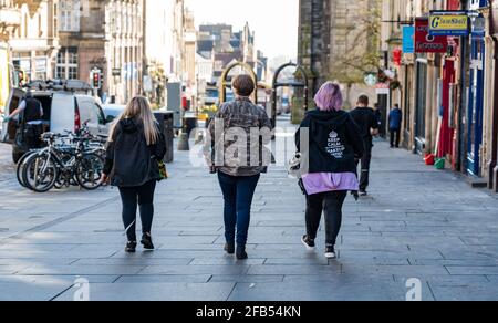 Drei Frauen bilden Künstler, die während der Dreharbeiten in Edinburgh, Schottland, Großbritannien, auf der Royal Mile als Teil des Filmteams unterwegs sind Stockfoto