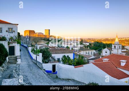 Obidos und das Schloss in der Abenddämmerung. Ein traditionelles mittelalterliches Dorf, das im 12. Jahrhundert in die Moore gebracht wurde. Portugal Stockfoto