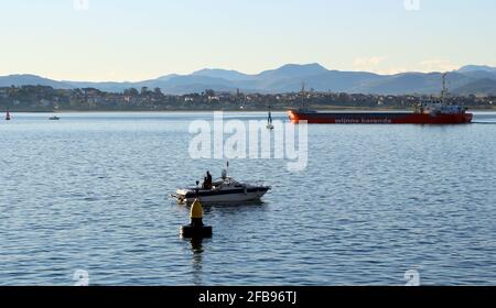 Das holländische Frachtschiff Lady Alexandra verlässt den Hafen von Santander Cantabria, Spanien, mit einem kleinen Fischerboot und einer Navigationsboje Stockfoto