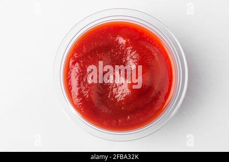 Kleine Tasse Tomatensauce, Draufsicht auf weißem Hintergrund Stockfoto