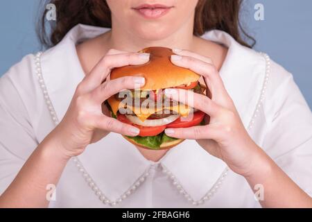 Riesiger und saftiger Burger, der von einem Weibchen gehalten wird Stockfoto