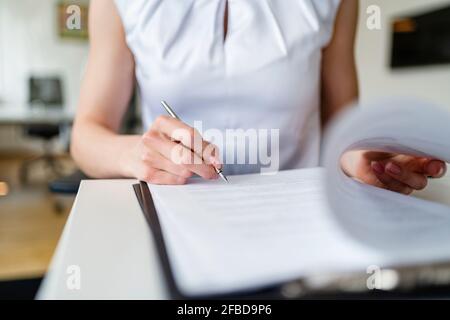 Geschäftsfrau unterzeichnet Vertrag im Büro Stockfoto