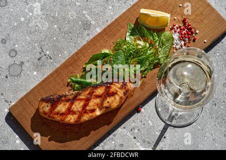 Makroaufnahme von gegrilltem Lachssteak mit bbq, frischem Gemüse. Gegrilltes Fischfilet mit roten Forellen, dekoriert mit würzigem Grün im Restaurant Stockfoto