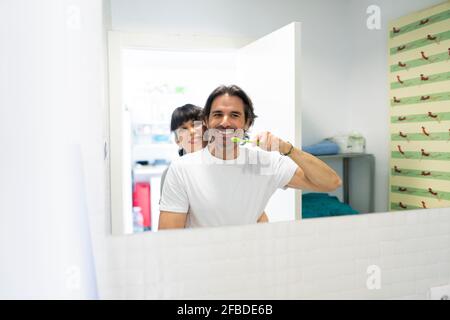 Frau umarmt Mann Zähneputzen im Bad zu Hause Stockfoto