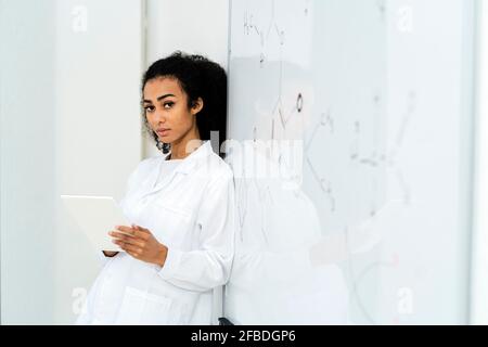 Junge Forscherin mit digitalem Tablet im Labor Stockfoto