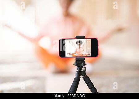 Frau, die sich während des Yoga über das Smartphone filmte Stockfoto