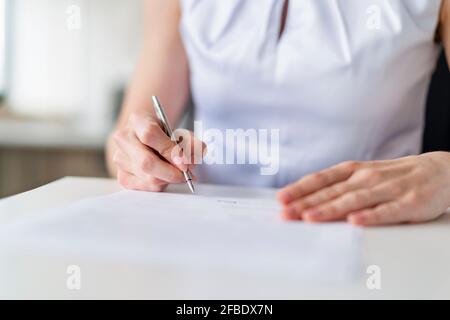 Geschäftsfrau unterzeichnet Vertrag im Büro Stockfoto