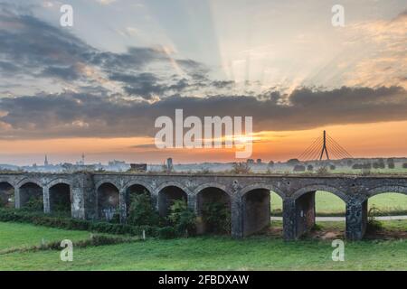 Deutschland, Nordrhein-Westfalen, Wesel, Altes Viadukt bei launischem Sonnenaufgang Stockfoto