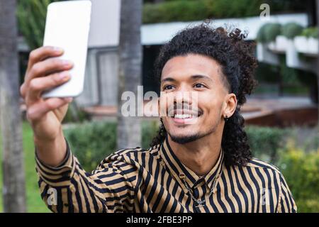 Lächelnder Mann, der Selfie über das Smartphone nimmt Stockfoto