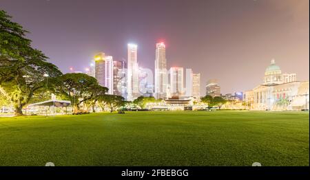 Singapur, Padang Field bei Nacht mit beleuchteter Skyline im Hintergrund Stockfoto